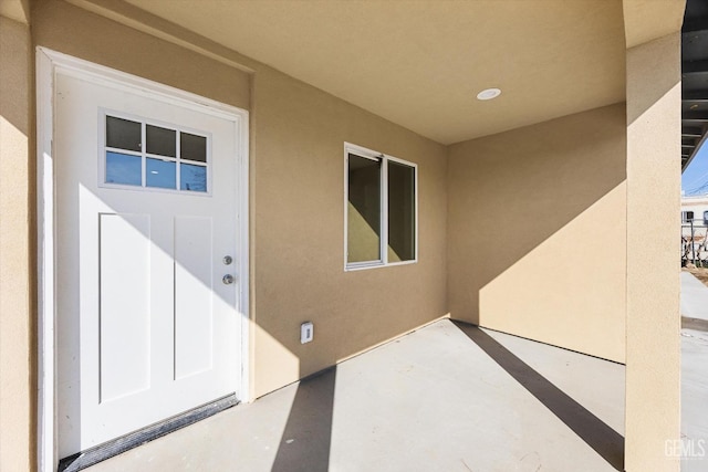 property entrance featuring a patio area and stucco siding