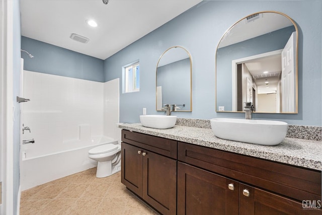 full bathroom with visible vents, double vanity, a sink, and toilet