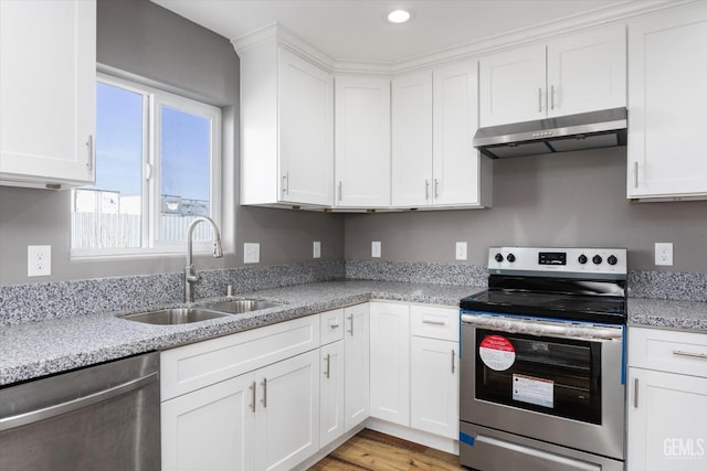 kitchen featuring stainless steel appliances, a sink, white cabinetry, and under cabinet range hood