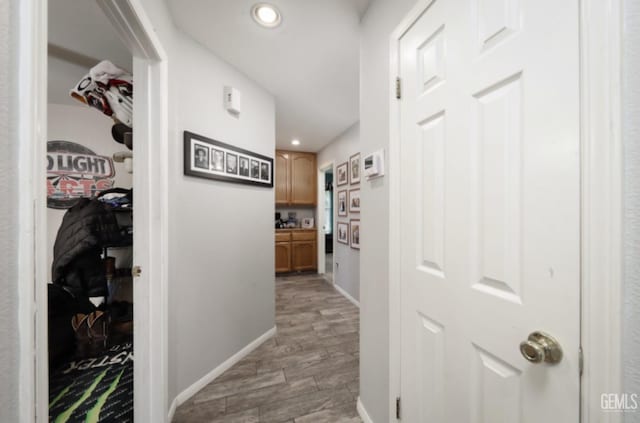 hallway with recessed lighting, light wood-style flooring, and baseboards