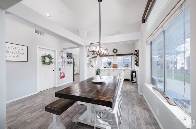 dining space with visible vents, wood finished floors, and plenty of natural light