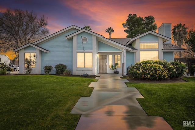 single story home featuring a chimney and a front lawn