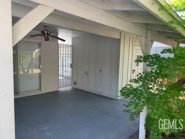 exterior space featuring ceiling fan and a gate