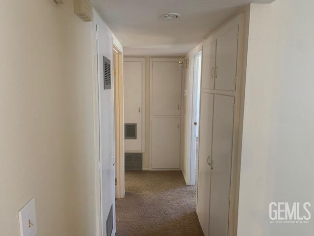 hallway featuring carpet flooring and visible vents