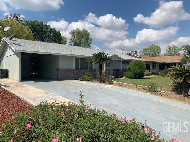 ranch-style home featuring an attached carport and driveway