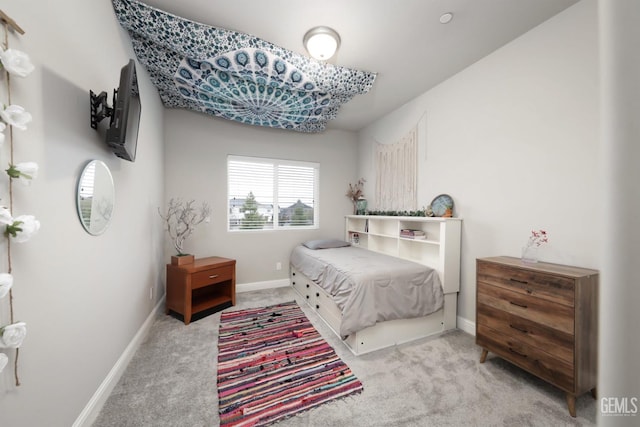 bedroom featuring light carpet and baseboards