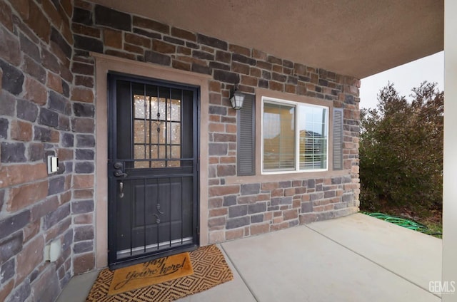 entrance to property featuring stone siding and brick siding