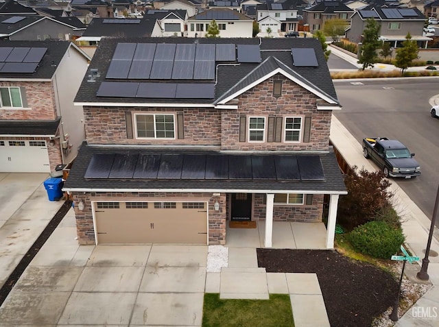 view of front of home featuring metal roof, concrete driveway, stone siding, a residential view, and a standing seam roof