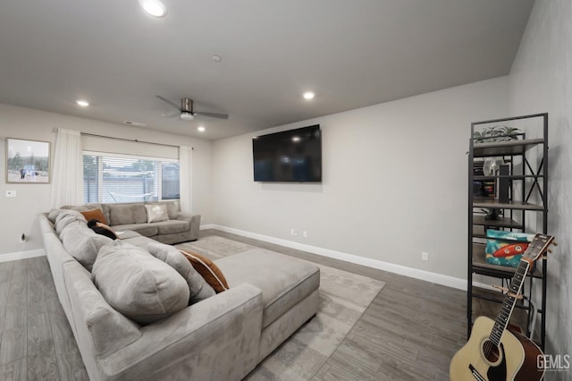 living room with baseboards, wood finished floors, and recessed lighting