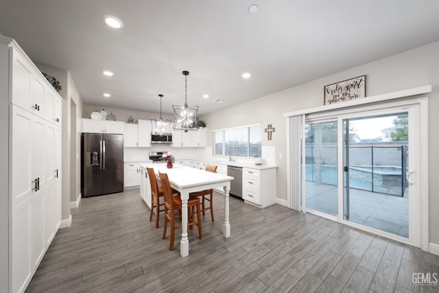 dining room featuring baseboards, wood finished floors, and recessed lighting