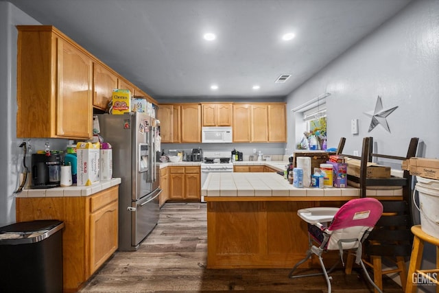 437 Rian Noelle Ct, Bakersfield, CA 93308 - kitchen with white appliances, dark wood-style floors, tile counters, recessed lighting, and a peninsula