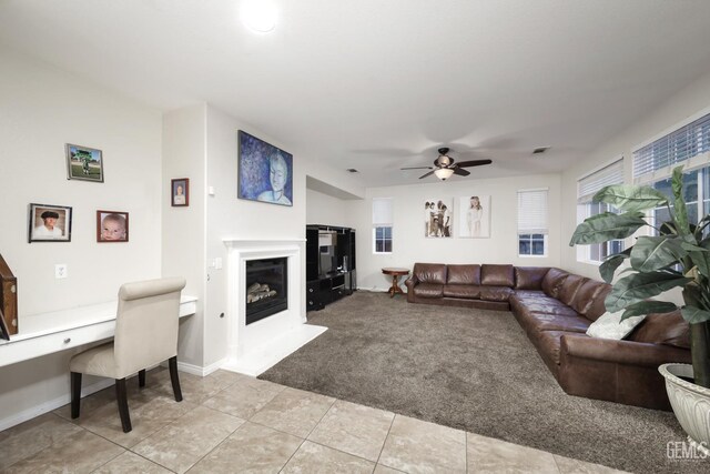11102 Patagonia Way, Bakersfield, CA 93306 - living room featuring light colored carpet, a glass covered fireplace, a desk, ceiling fan, and light tile patterned floors