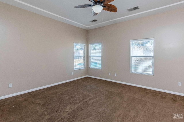 carpeted spare room featuring visible vents, baseboards, and a ceiling fan