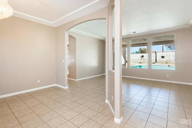 unfurnished room featuring light tile patterned floors, visible vents, arched walkways, and baseboards