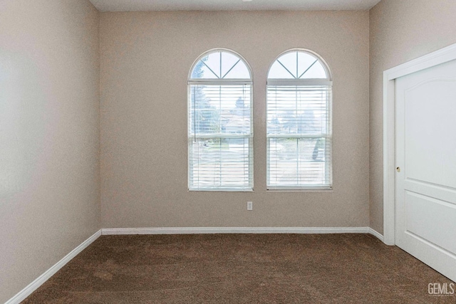 unfurnished room featuring carpet and baseboards