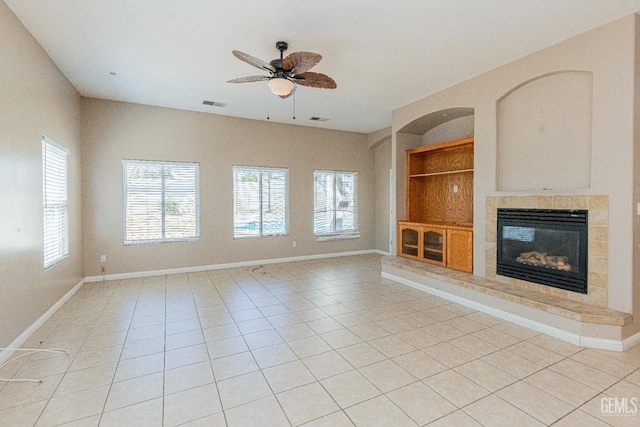 unfurnished living room featuring visible vents, baseboards, built in features, light tile patterned floors, and a fireplace