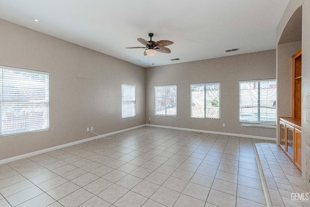 unfurnished living room with light tile patterned floors, visible vents, baseboards, and ceiling fan