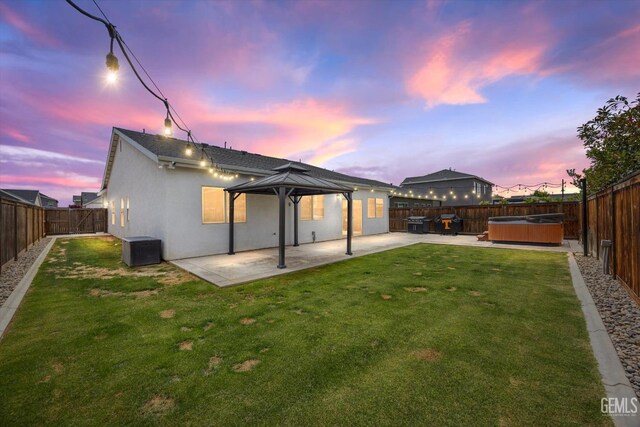 9008 Pine Breeze Ln, Shafter, CA 93263 - rear view of property with a gazebo, a hot tub, stucco siding, a fenced backyard, and a patio