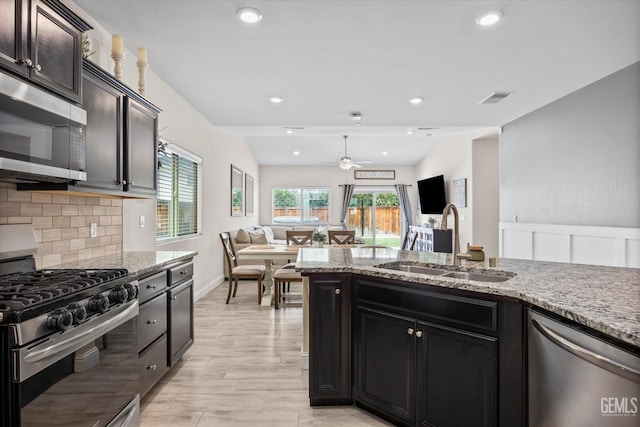 9008 Pine Breeze Ln, Shafter, CA 93263 - kitchen with visible vents, a ceiling fan, light stone countertops, a sink, and appliances with stainless steel finishes