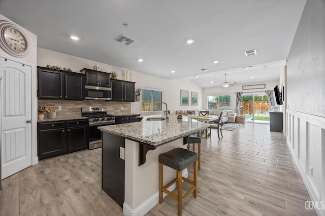 9008 Pine Breeze Ln, Shafter, CA 93263 - kitchen featuring a sink, stainless steel appliances, a kitchen bar, and visible vents