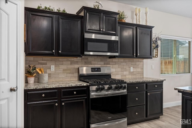 9008 Pine Breeze Ln, Shafter, CA 93263 - kitchen featuring dark cabinetry, appliances with stainless steel finishes, and tasteful backsplash