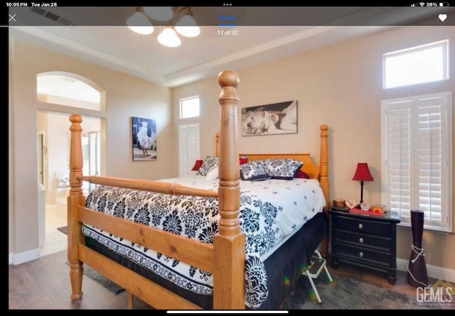 bedroom featuring ensuite bath and dark hardwood / wood-style floors