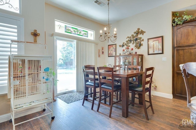 dining area with dark hardwood / wood-style floors and a chandelier