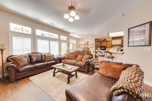 living room featuring light wood-type flooring and an inviting chandelier