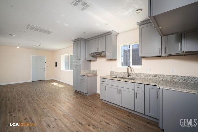 428 Center St Unit A, Taft, CA 93268 - kitchen with gray cabinets, under cabinet range hood, wood finished floors, and light stone counters