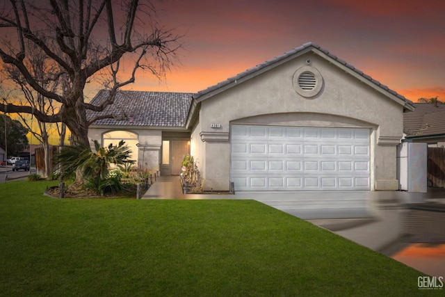 view of front facade featuring a garage and a lawn