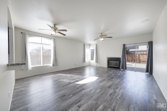 unfurnished living room with dark hardwood / wood-style floors and ceiling fan