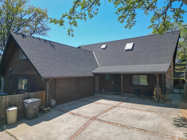 view of front of property with roof with shingles, driveway, an attached garage, and covered porch