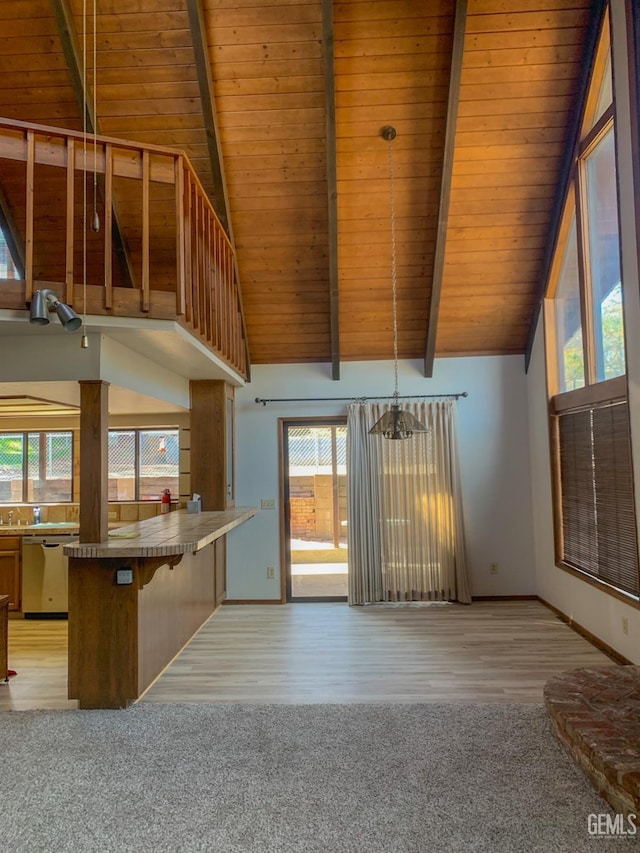unfurnished living room with baseboards, light wood-type flooring, beam ceiling, high vaulted ceiling, and wooden ceiling