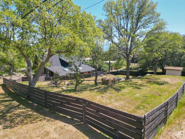 view of yard featuring fence private yard, an outdoor structure, and a storage unit