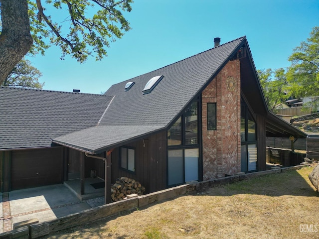 back of house featuring a patio and a shingled roof