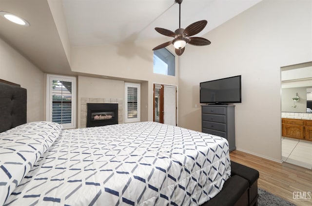 7305 Wilford Ct, Bakersfield, CA 93309 - bedroom featuring light wood finished floors, multiple windows, a tiled fireplace, baseboards, and high vaulted ceiling