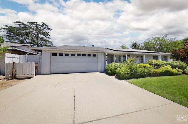 712 River Oaks Dr, Bakersfield, CA 93309 - single story home featuring an attached garage, concrete driveway, roof mounted solar panels, and board and batten siding