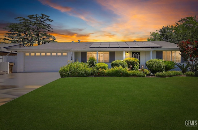 712 River Oaks Dr, Bakersfield, CA 93309 - ranch-style home featuring a garage, a lawn, solar panels, and concrete driveway