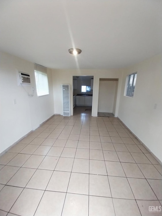 empty room featuring a wall unit AC and light tile patterned floors