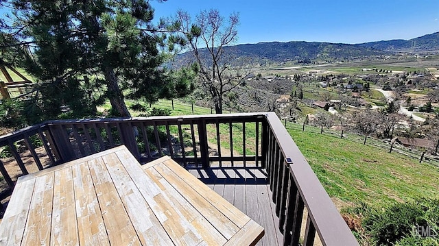 wooden deck with a yard, fence, and a mountain view