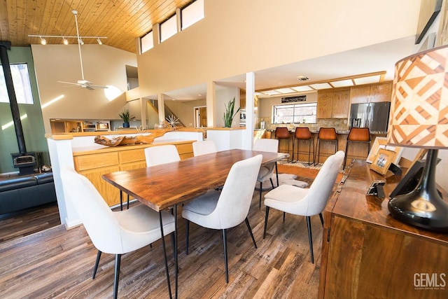 dining space featuring a wealth of natural light, a wood stove, and wood finished floors