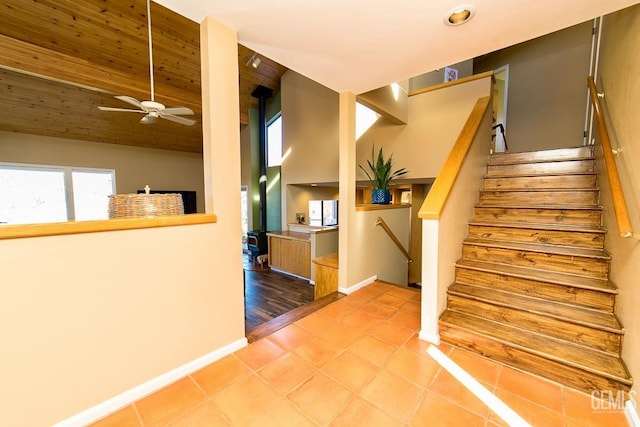 stairway featuring ceiling fan, baseboards, vaulted ceiling, and tile patterned floors