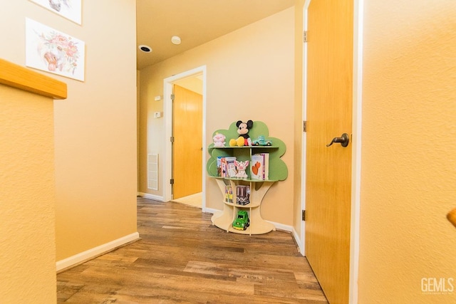 corridor featuring baseboards and wood finished floors