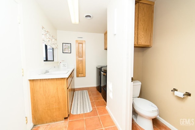 bathroom with visible vents, toilet, washing machine and clothes dryer, tile patterned flooring, and vanity