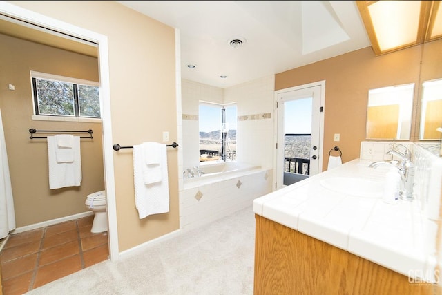 bathroom with a garden tub, toilet, a sink, visible vents, and double vanity