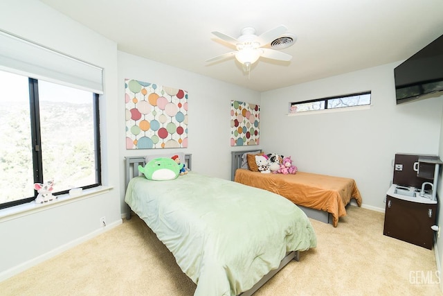 bedroom featuring carpet floors, multiple windows, visible vents, and baseboards