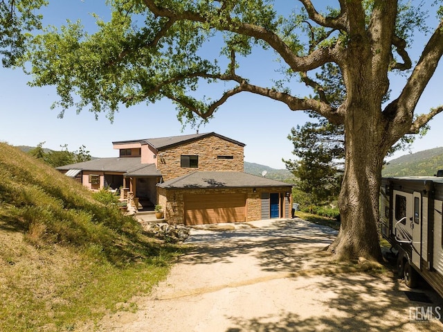 view of front of house featuring stone siding and driveway