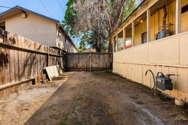 view of yard with fence and water heater