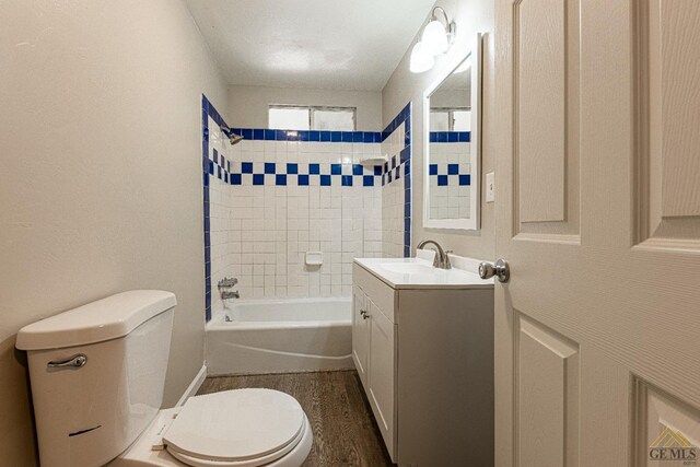 bathroom with vanity, wood finished floors, bathing tub / shower combination, and toilet