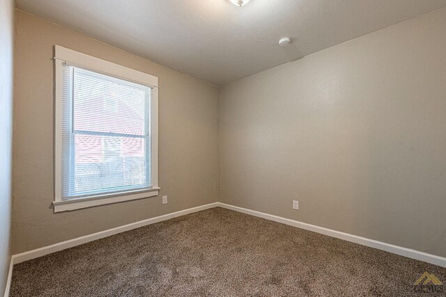 unfurnished room with baseboards and carpet
